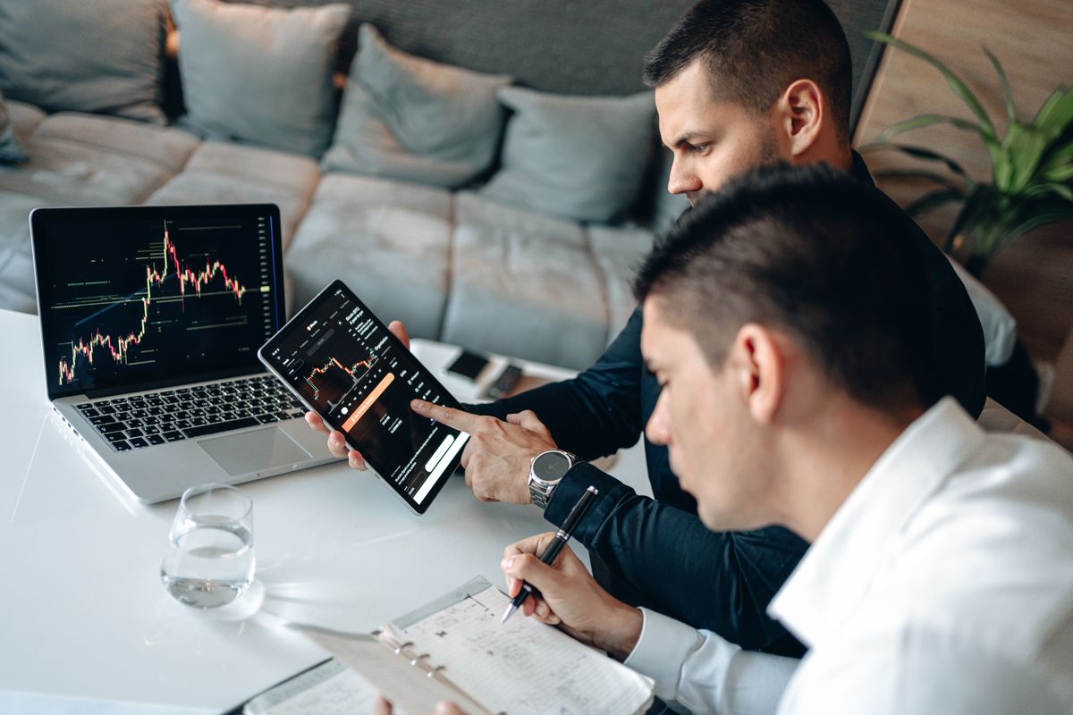 Traders analyzing market charts on a laptop and tablet